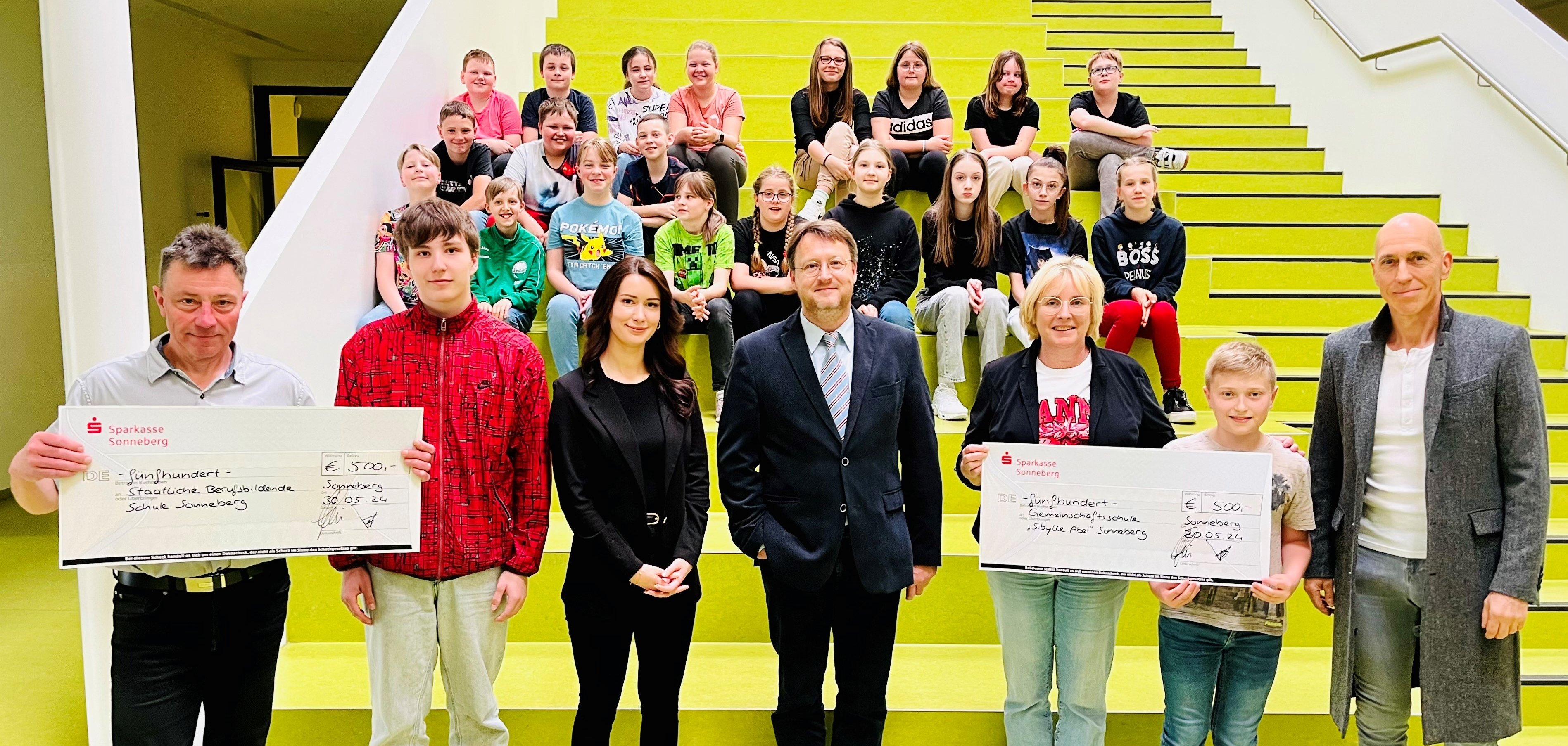 Die beiden Schulleiter Steffen Werner (l.) und Ute Salzer (3.v.r.) freuten sich über das Preisgeld der Sparkasse Sonneberg, welches durch die Marketing-Verantwortliche Anna Hermann (3.v.l.) im Beisein von Dr. Dirk Botthäuser (r.) und Landrat Robert Sesselmann (M.) an die beiden Schulfamilien übergeben wurde.