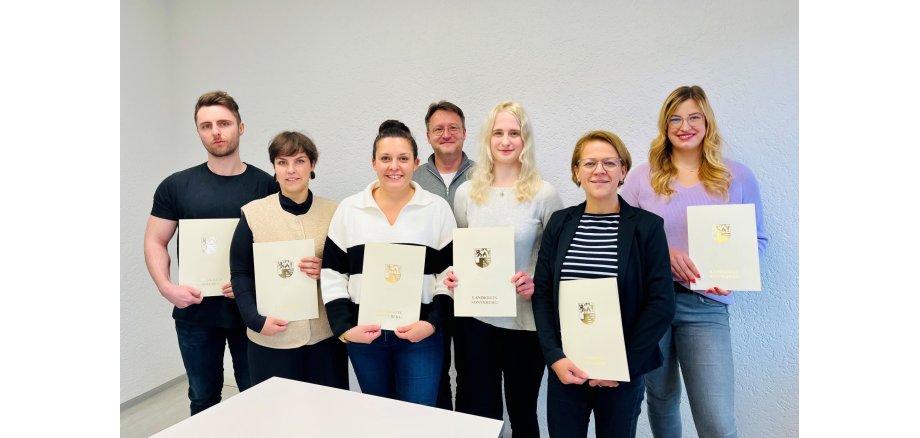Gruppenfoto mit den Absolventinnen und Absolventen des jüngsten Lehrgangs zum Ausbilderschein, Personen von links nach rechts: Dominic-Christopher Eichhorn, Anna Wittmann, Theresa Meusel, Lea Ehrlicher, Christina Schilling und Melissa Wolf – hier mit Landrat Robert Sesselmann