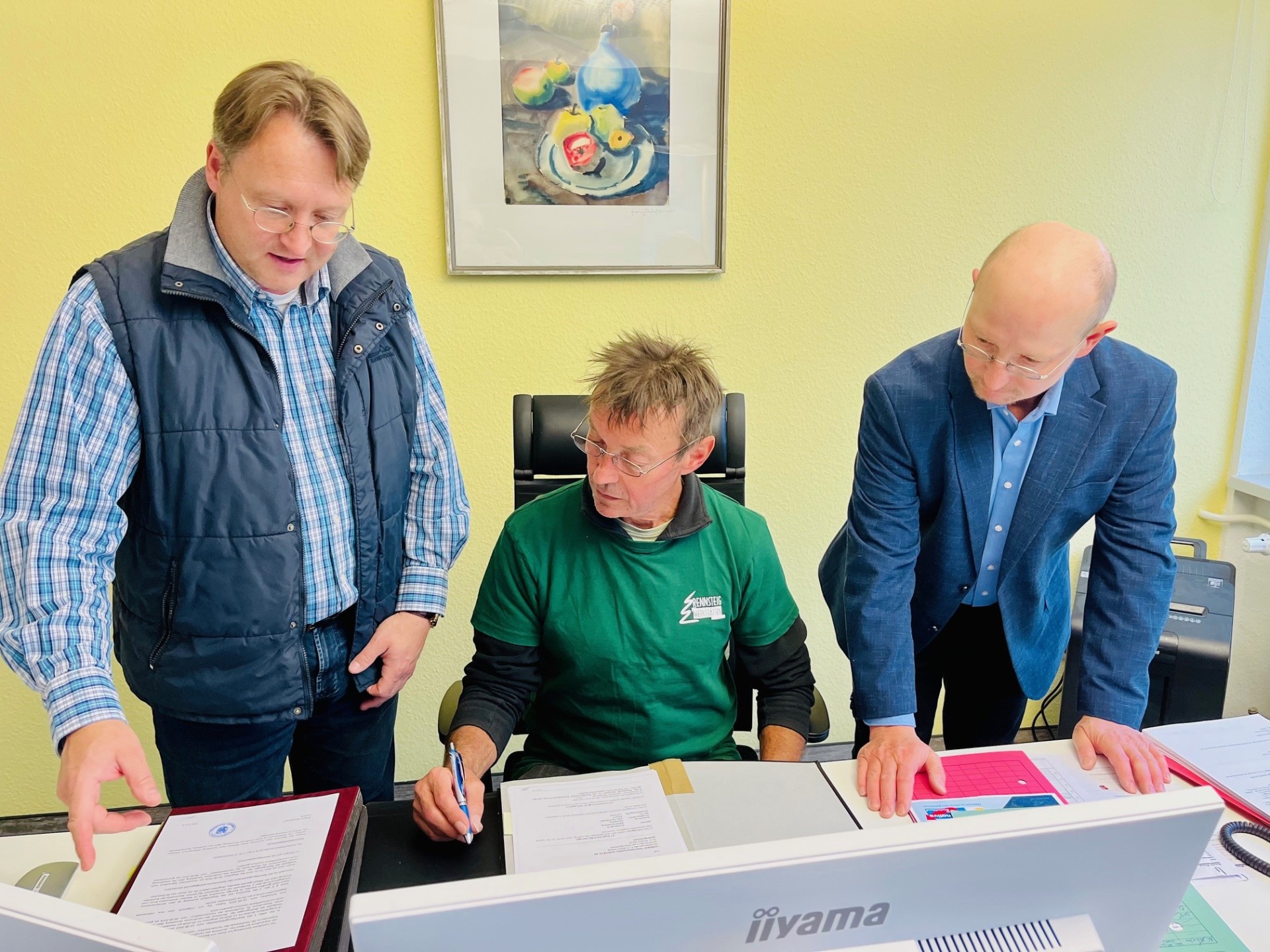 Auf dem Stuhl des Landrates: Bernd Reißmann mit Landrat Robert Sesselmann und Vize-Landrat Andreas Groß während des Aktionstages „Schichtwechsel“ im Landratsamt