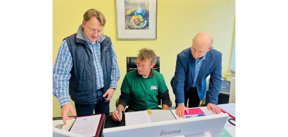 Auf dem Stuhl des Landrates: Bernd Reißmann mit Landrat Robert Sesselmann und Vize-Landrat Andreas Groß während des Aktionstages „Schichtwechsel“ im Landratsamt