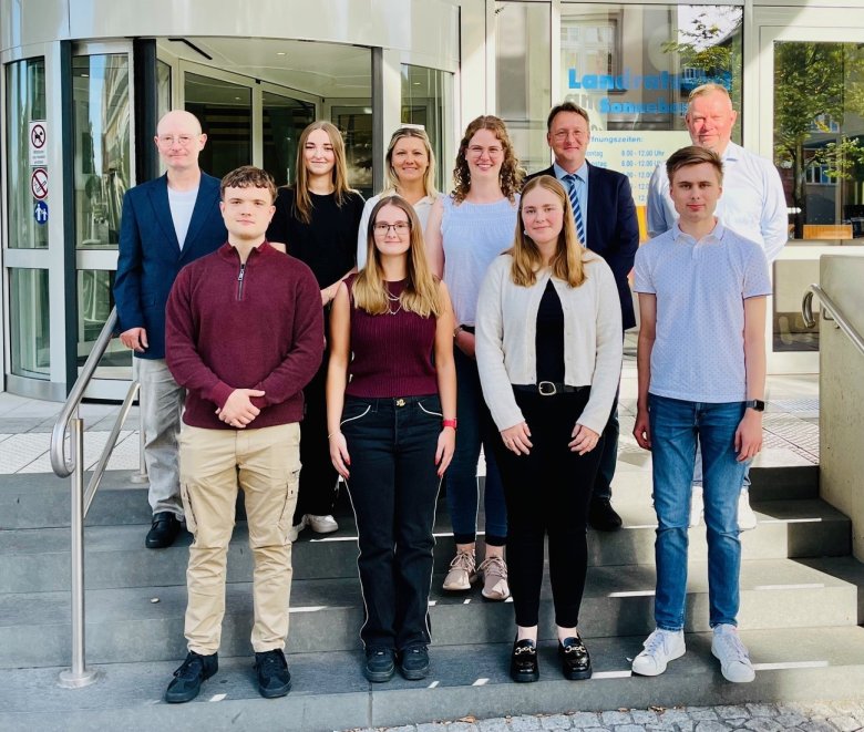 Die Nachwuchskräfte Leonie Graul (hinten 2.v.l.), Pascal Jahn (vorne l.), Emily Sperschneider (vorne 2.v.l.), Vivien Sophie Schwesinger (vorne 2.v.r.) und Tom Unbehaun (vorne r.) mit Landrat Robert Sesselmann (hinten, 2.v.r.), dem Hauptamtlichen Beigeordneten Andreas Groß (hinten, l.), den Ausbildungsleiterinnen Carolin Engelbrecht (hinten 3.v.l.) und Josefine Weidenhammer (hinten 3.v.r.) sowie Personalamtsleiter Steffen Zinner (hinten r.) Die Nachwuchskräfte Leonie Graul (hinten 2.v.l.), Pascal Jahn (vorne l.), Emily Sperschneider (vorne 2.v.l.), Vivien Sophie Schwesinger (vorne 2.v.r.) und Tom Unbehaun (vorne r.) mit Landrat Robert Sesselmann (hinten, 2.v.r.), dem Hauptamtlichen Beigeordneten Andreas Groß (hinten, l.), den Ausbildungsleiterinnen Carolin Engelbrecht (hinten 3.v.l.) und Josefine Weidenhammer (hinten 3.v.r.) sowie Personalamtsleiter Steffen Zinner (hinten r.)