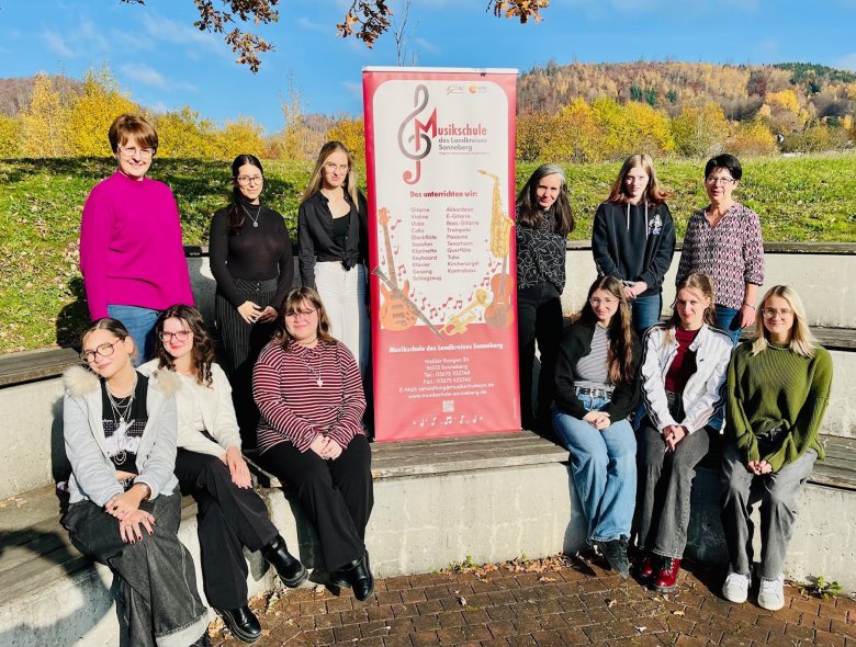 Die Schülerinnen der Gestalter-Klasse am Beruflichen Gymnasium der SBBS mit Fachlehrerin Franziska Laue (hinten, 3.v.r.), der stellvertretenden SBBS-Schulleiterin Elke Herrling (hinten l.) und Musikschulleiterin Petra Adelbert (hinten r.) mit dem Rollbanner, auf dem das neue Logo der Musikschule prangt Die Schülerinnen der Gestalter-Klasse am Beruflichen Gymnasium der SBBS mit Fachlehrerin Franziska Laue (hinten, 3.v.r.), der stellvertretenden SBBS-Schulleiterin Elke Herrling (hinten l.) und Musikschulleiterin Petra Adelbert (hinten r.) mit dem Rollbanner, auf dem das neue Logo der Musikschule prangt