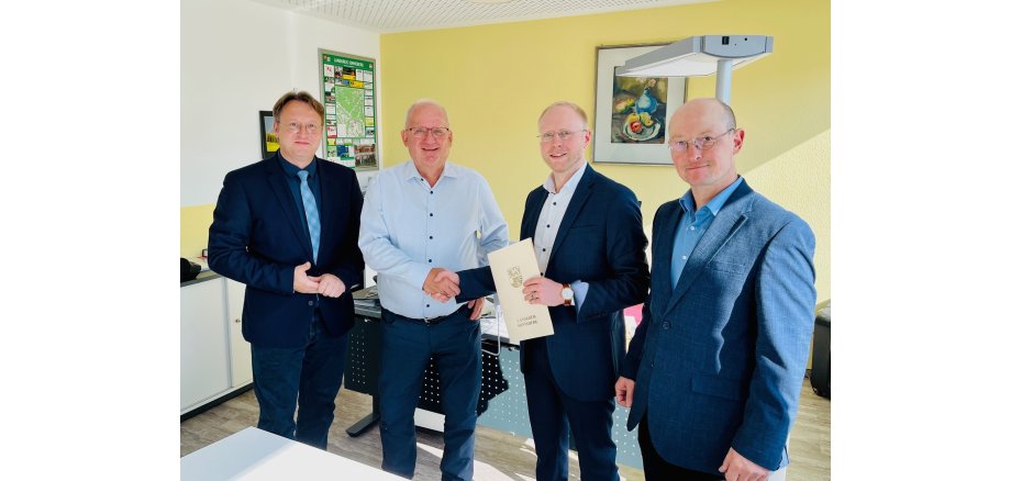 Handschlag zwischen dem scheidenden OVG-Geschäftsführer Klaus Dieter Schneider (2.v.l.) und seinem Nachfolger Matthias Böhm (2.v.r.) im Beisein von Landrat Robert Sesselmann (l.) und dem Hauptamtlichen Beigeordneten Andreas Groß
