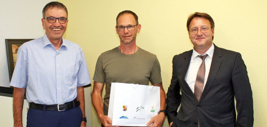 Ralf Kirchner (M.) umringt von Landrat Robert Sesselmann (r.) und Uwe Scheler, Leiter des Amts für Kreisentwicklung, ÖPNV und Kultur im Landratsamt Sonneberg (l.)