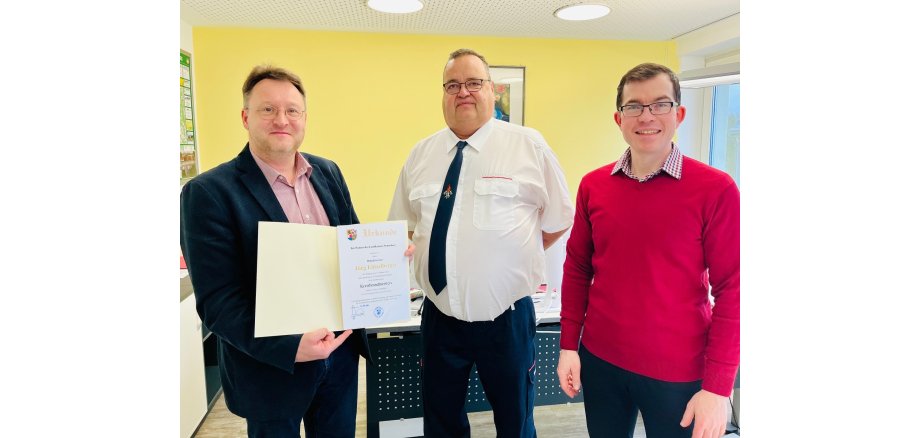 Übergabe der Ernennungsurkunde zum Kreisbrandmeister an Jörg Lützelberger (M.) durch Landrat Robert Sesselmann (l.) im Beisein von Kreisbrandinspektor Mathias Nüchterlein (r.)